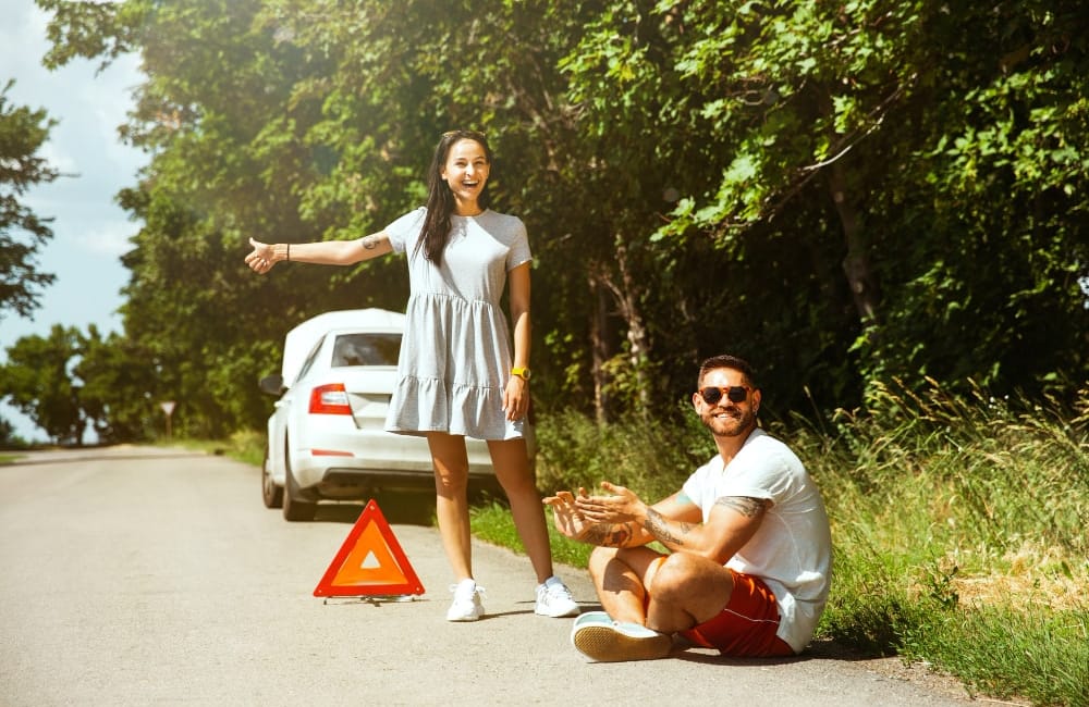 A young couple with a broken-down car